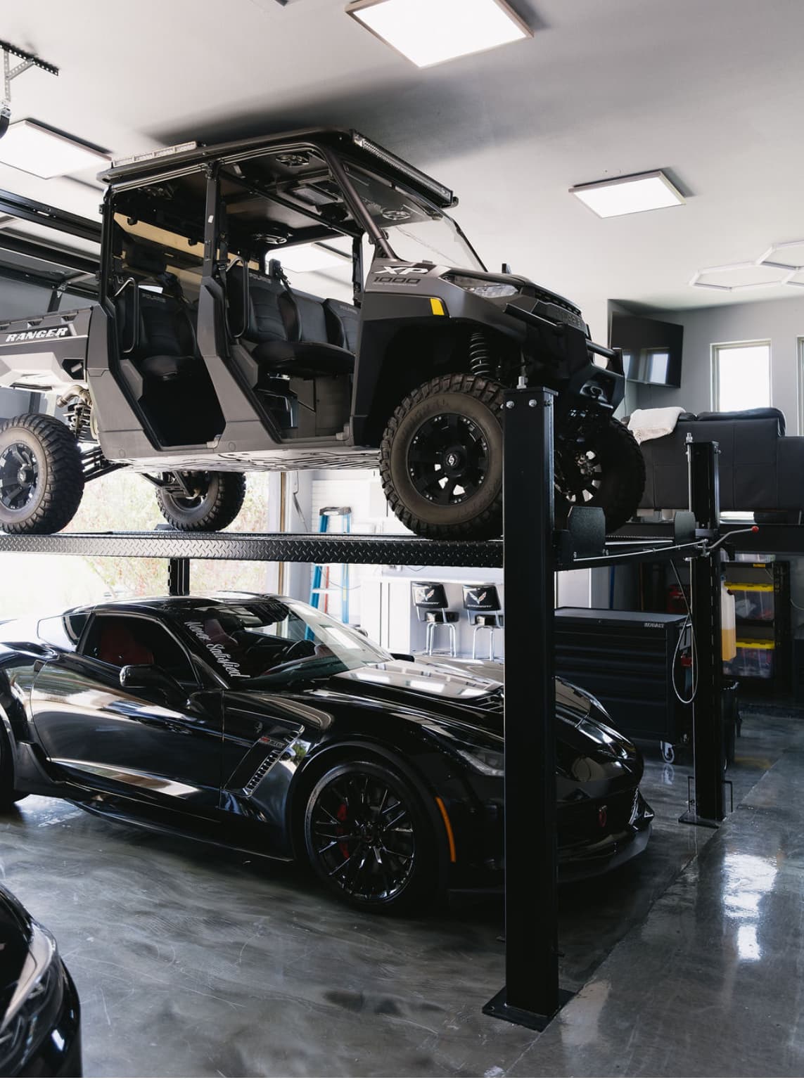 Bright LED-lit garage with car lift and vehicles by My Ultimate Garage